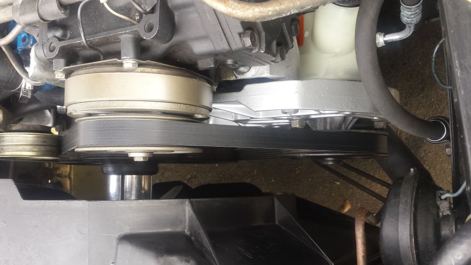 Serpentine belt system on a V8 engine, power steering pump and alternator pulleys.