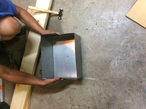 1979 Ford Bronco - A person is working on a metal box with a hammer and wooden planks. The scene appears to be a workshop or garage.