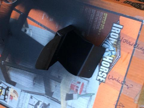 1979 Ford Bronco - A black metal part sits on top of an orange and white cardboard box with "IRON HORSE" printed on it. A paintbrush is visible on the box.