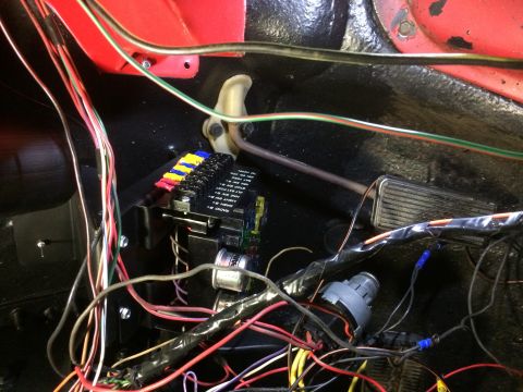 1979 Ford Bronco - This image shows a close-up view of the wiring harness and fuse box under the dashboard of a classic vehicle. Wires are neatly organized an…