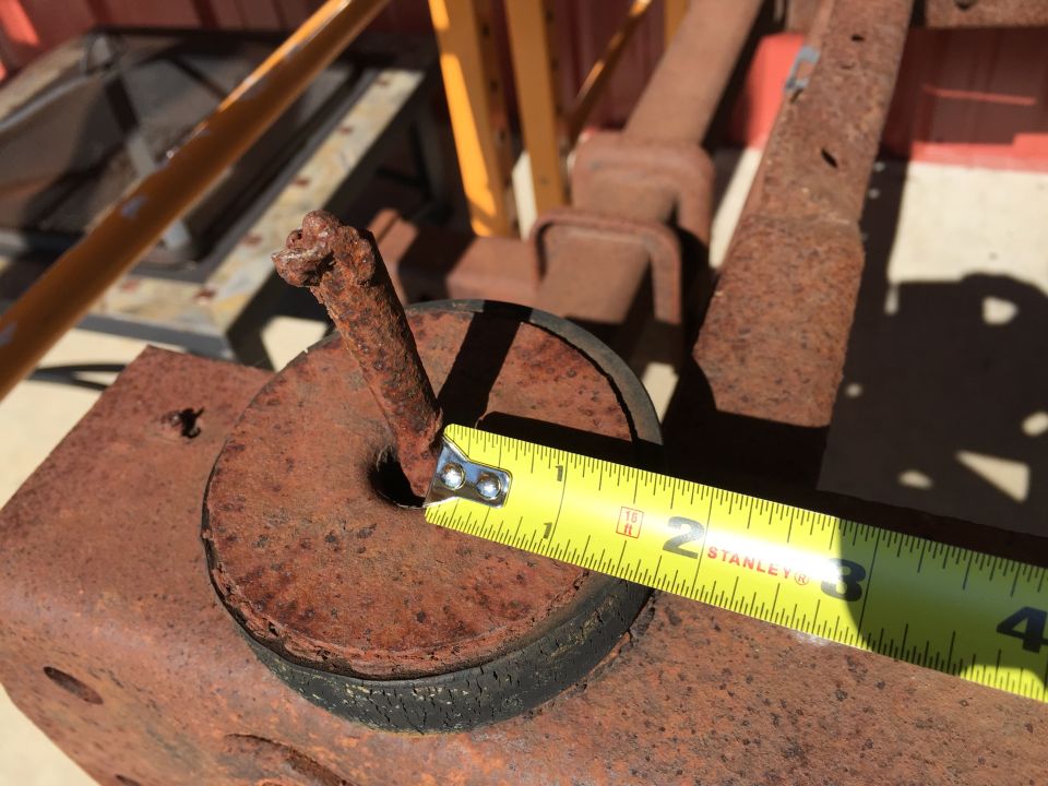 Rusty vehicle part with a tape measure showing approximately 2.5 inches.