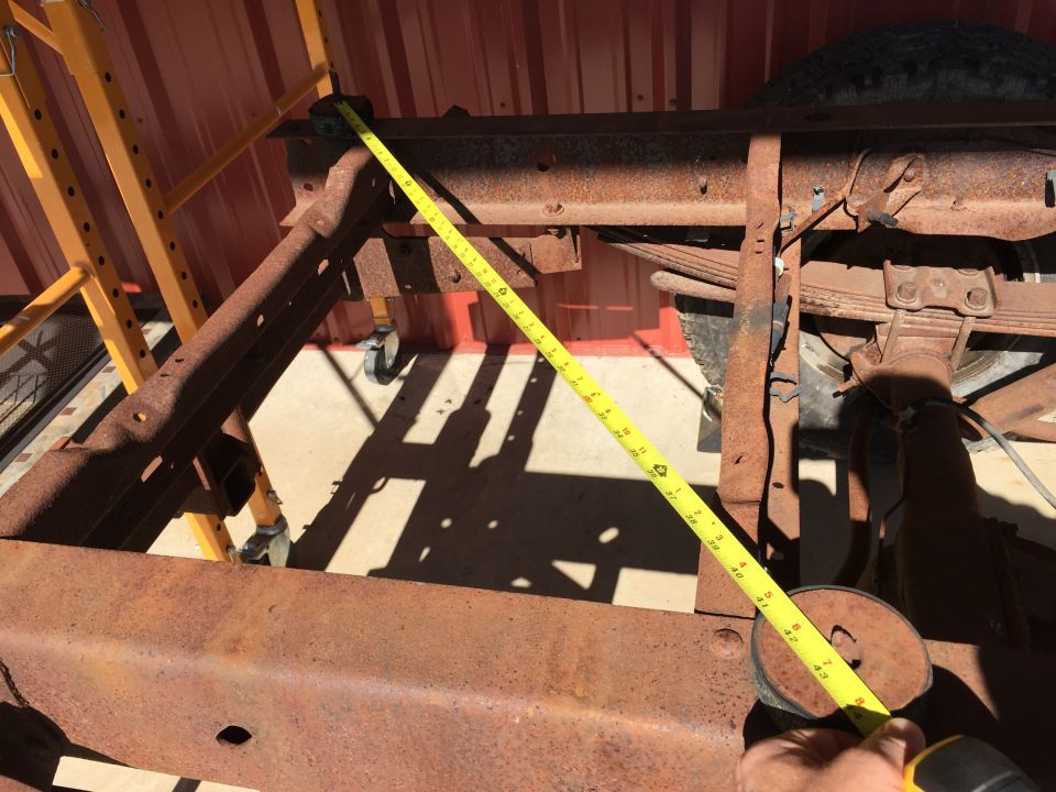 Close-up of a rusty vehicle frame with a yellow measuring tape showing 41 inches.