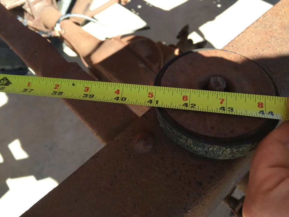 Yellow measuring tape on rusty metal part, measuring approximately 43.5 inches.