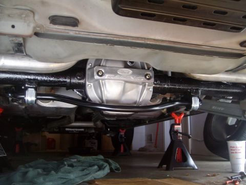 2004 Ford Crown Victoria - Underneath view of a Ford Racing differential cover and sway bar assembly on a vehicle supported by jack stands.