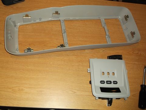 1999 Mercury Grand Marquis - A light gray interior trim piece with cutouts for buttons and a display is shown, along with a larger, similarly colored trim piece with mo…