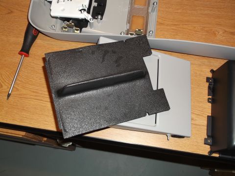 1999 Mercury Grand Marquis - A disassembled interior light fixture and a black textured plastic cover are on a wooden surface. A Torx screwdriver is also visible.
