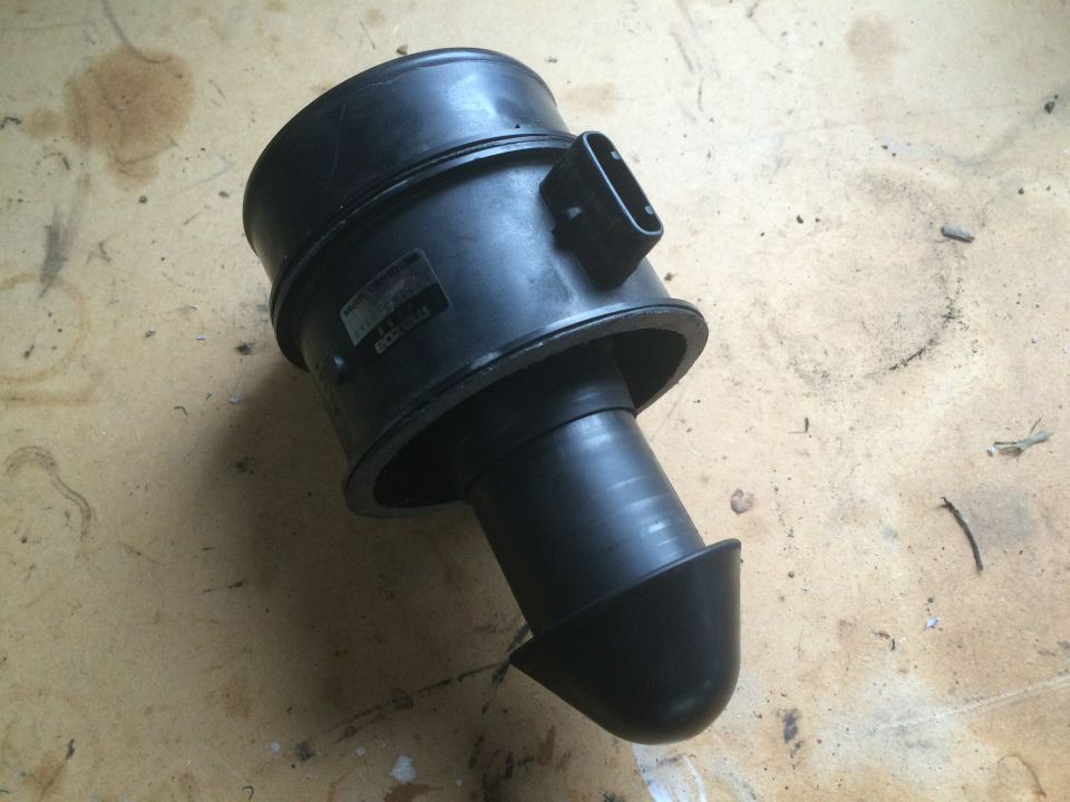 Black automotive mass airflow sensor housing with a label.