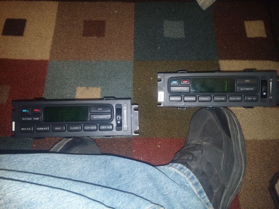 Two Ford automatic climate-control panels on patterned carpet