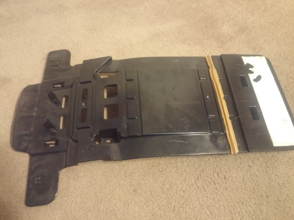 Black molded plastic interior bracket or housing on carpet