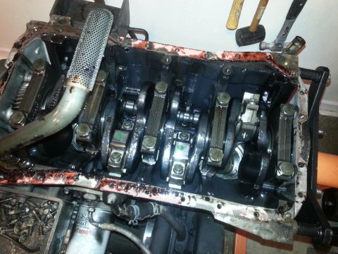 1994 Ford Bronco - The internal components of a vehicle engine are visible, including the crankshaft, connecting rods, and oil pickup tube. The engine block a…