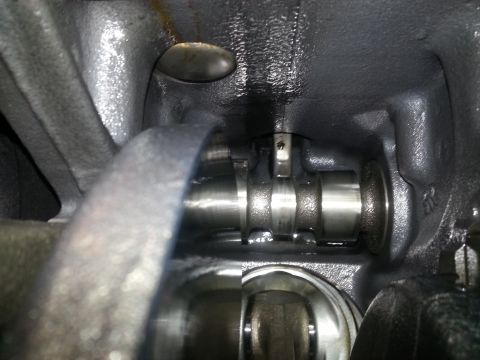 1994 Ford Bronco - A close-up view of the internal components of an engine, likely a camshaft, showing metal parts with oil residue.