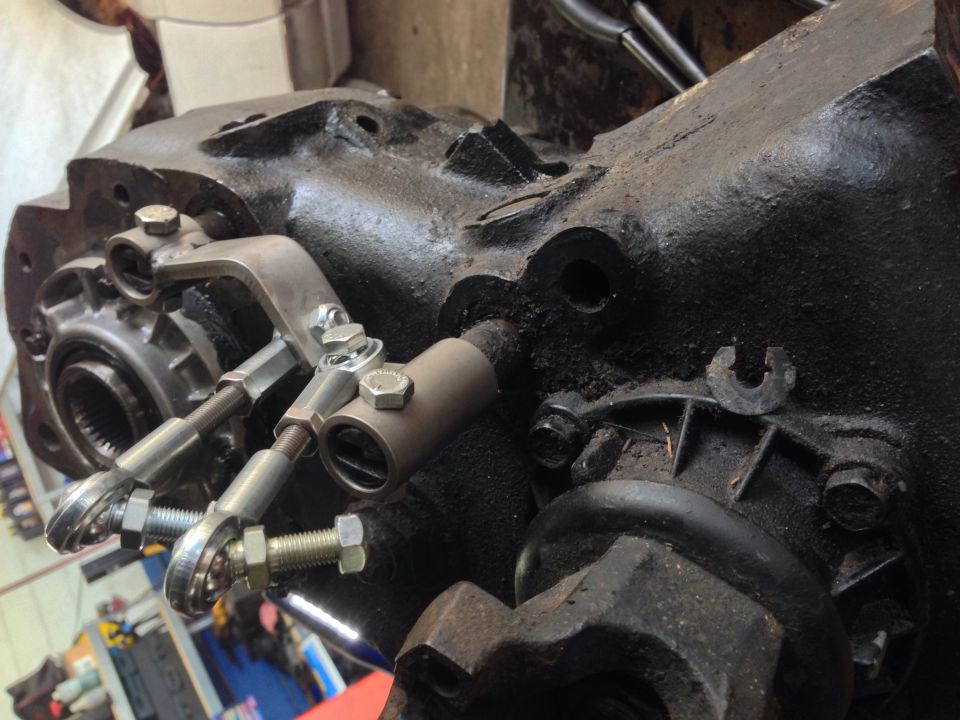 Modified transfer case with custom linkage rods and lever mechanism.