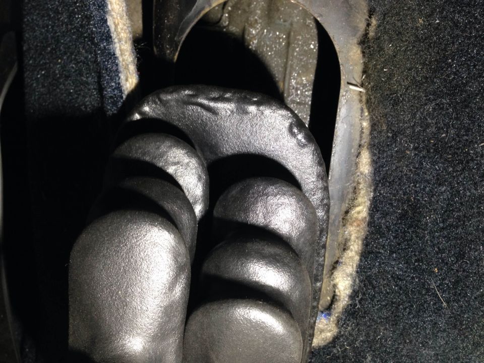 Close-up of vehicle pedals, clutch and brake, with dark carpet.