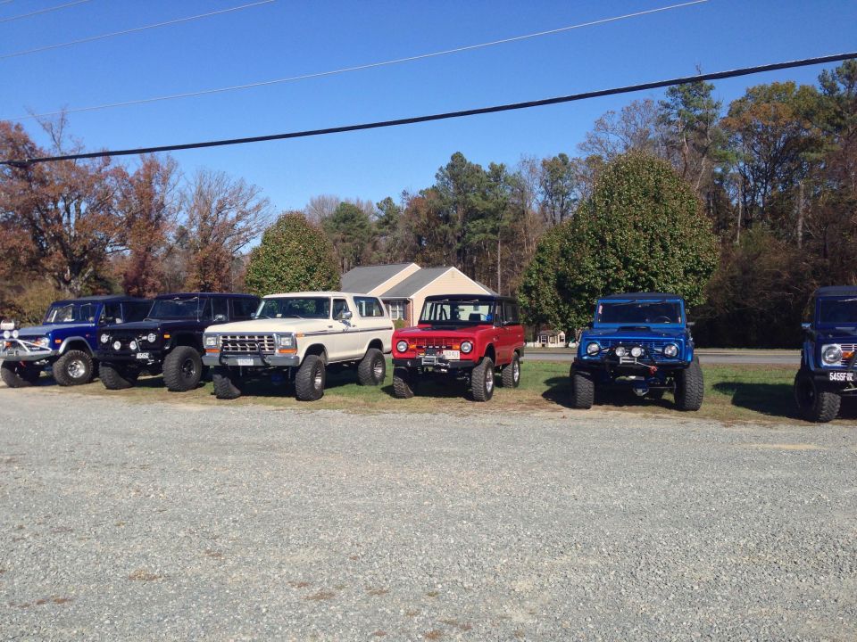 White 1979 Ford Bronco parked in a line with other off-road vehicles.