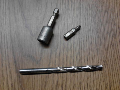 1989 Ford Bronco - A drill bit, a magnetic nut driver, and a screwdriver bit are laid out on a wooden surface.