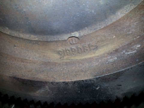 1994 Ford Bronco - A close-up view of a rusty metal ring with embossed numbers that read '990615'. The ring appears to be part of a vehicle component, possibl…