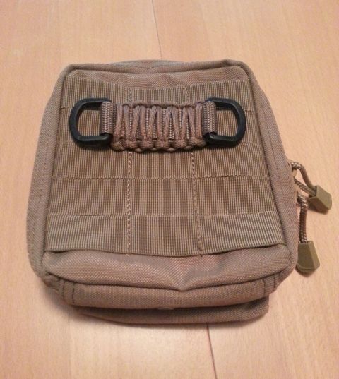 2003 Ford Crown Victoria - A close-up view of a tan tactical pouch with paracord and D-rings.