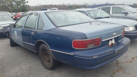 1991 Ford LTD Crown Victoria - This two-tone blue sedan is parked in a lot with other cars visible.
