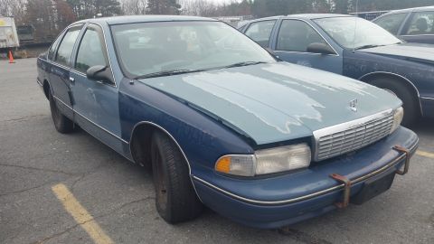 1991 Ford LTD Crown Victoria - A blue sedan with a mismatched hood sits in a parking lot next to another vehicle.