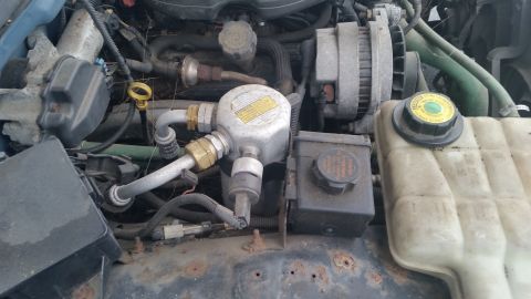 1991 Ford LTD Crown Victoria - Photograph of an engine bay with alternator, filter and hoses, not a technical document.