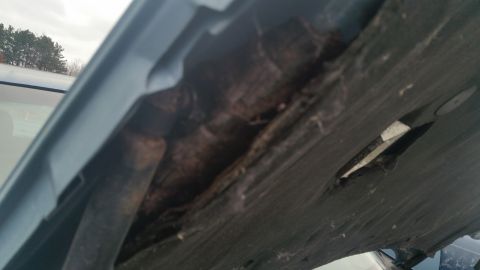 1991 Ford LTD Crown Victoria - Photograph of a rusted, corroded body seam on a vehicle, not a technical document.
