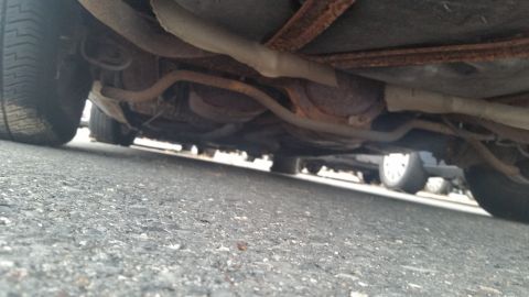 1991 Ford LTD Crown Victoria - Photograph of a vehicle undercarriage with exhaust and suspension, not a technical document.