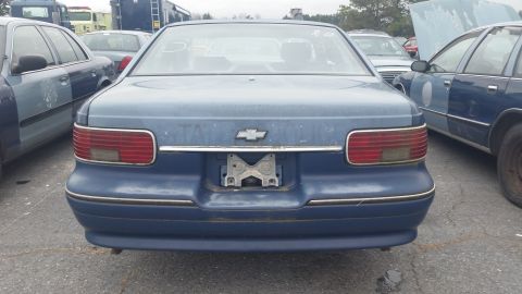 1991 Ford LTD Crown Victoria - Photograph of the rear of a faded blue Chevrolet Caprice sedan, not a technical document.