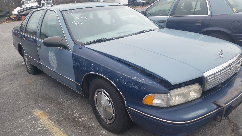 Blue Chevrolet Caprice sedan with worn paint parked outdoors
