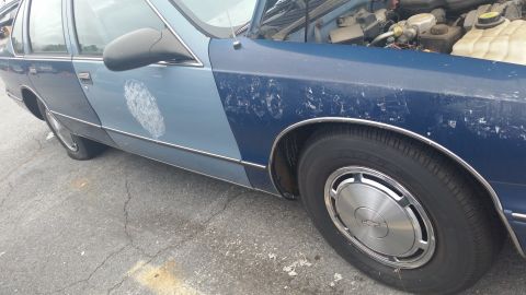 1991 Ford LTD Crown Victoria - Photograph of the side and front wheel of a blue Caprice, not a technical document.