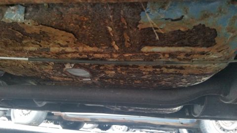 1991 Ford LTD Crown Victoria - Photograph of a rusted vehicle underbody and frame crossmember, not a technical document.