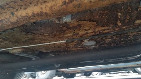 1991 Ford LTD Crown Victoria - Photograph of a corroded vehicle underbody and frame, not a technical document.