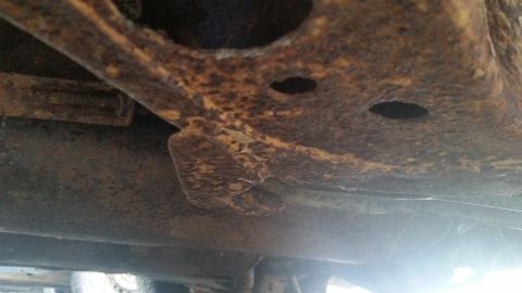 1991 Ford LTD Crown Victoria - Photograph of a rusted vehicle frame bracket, not a technical document.