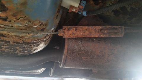 1991 Ford LTD Crown Victoria - Photograph of a vehicle underbody fuel tank and exhaust components, not a technical document.