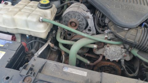 1991 Ford LTD Crown Victoria - Photograph of a V8 engine bay with hoses and coolant reservoir, not a technical document.