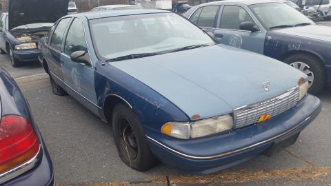 1991 Ford LTD Crown Victoria - Photograph of a faded blue Chevrolet sedan, not a technical document.