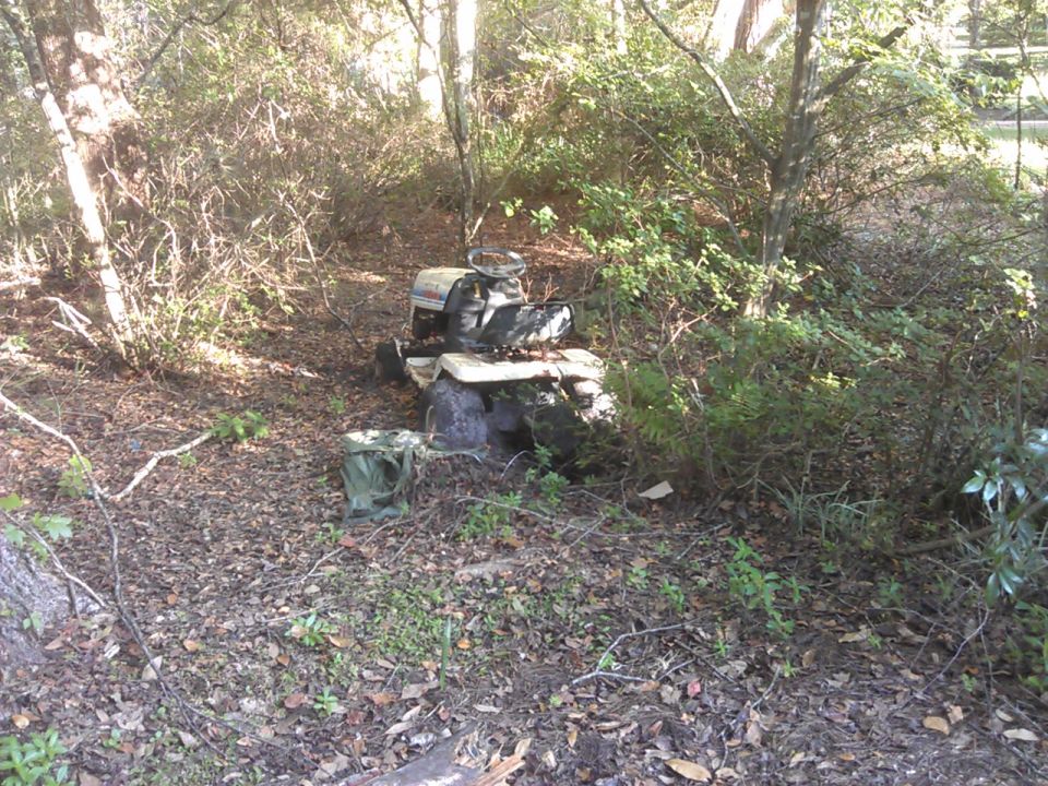Riding lawn mower in a wooded area.