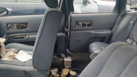 1991 Ford LTD Crown Victoria - Photograph of a vehicle rear seat and damaged door panels, not a technical document.