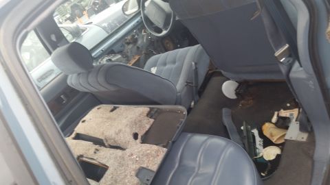 1991 Ford LTD Crown Victoria - Photograph of a vehicle front interior with worn carpet, not a technical document.
