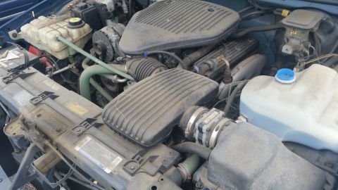 1991 Ford LTD Crown Victoria - Photograph of an engine compartment showing the V8 intake, air cleaner housing, and coolant reservoir, not a document.