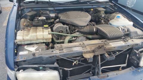 1991 Ford LTD Crown Victoria - Photograph of an open engine compartment with radiator support and intake, not a document.