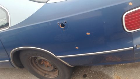 1991 Ford LTD Crown Victoria - Photograph of a blue sedan's rear quarter panel and taillight, not a document.