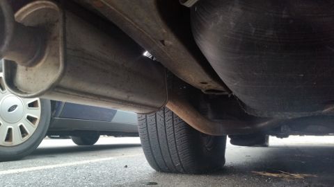 1991 Ford LTD Crown Victoria - Photograph of a muffler and exhaust pipe beneath a vehicle, not a document.