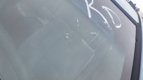 1991 Ford LTD Crown Victoria - Photograph through a windshield with marker letters and a visible interior, not a document.
