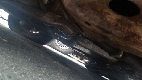 1991 Ford LTD Crown Victoria - Photograph of a vehicle undercarriage with a rusty frame and rear brake, not a document.