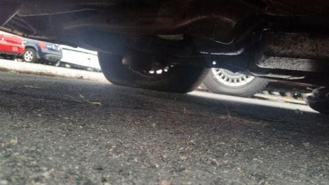 1991 Ford LTD Crown Victoria - Photograph of a vehicle's rear undercarriage showing the axle and exhaust, not a document.