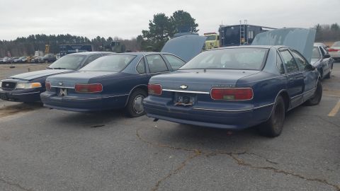 1991 Ford LTD Crown Victoria - Photograph of two blue Chevrolet Caprice sedans parked outdoors, not a document.