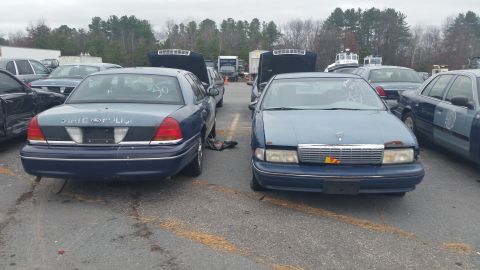 1991 Ford LTD Crown Victoria - Photograph of a Ford Crown Victoria and a Chevrolet Caprice parked in an outdoor lot, not a document.
