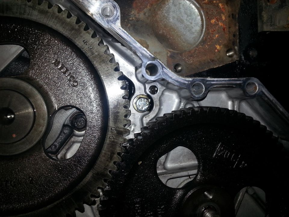 Close-up of engine gears, one silver with text "MEXICO REV 06", the other black.