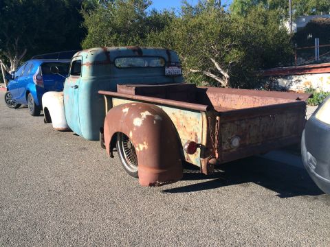 1968 Ford Mustang - Photograph of a weathered teal-and-rust 1940s pickup truck parked in a lot.