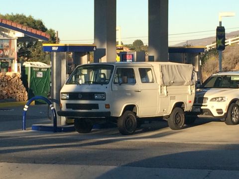 1968 Ford Mustang - Photograph of a white Volkswagen Transporter double-cab pickup parked at a fuel pump.